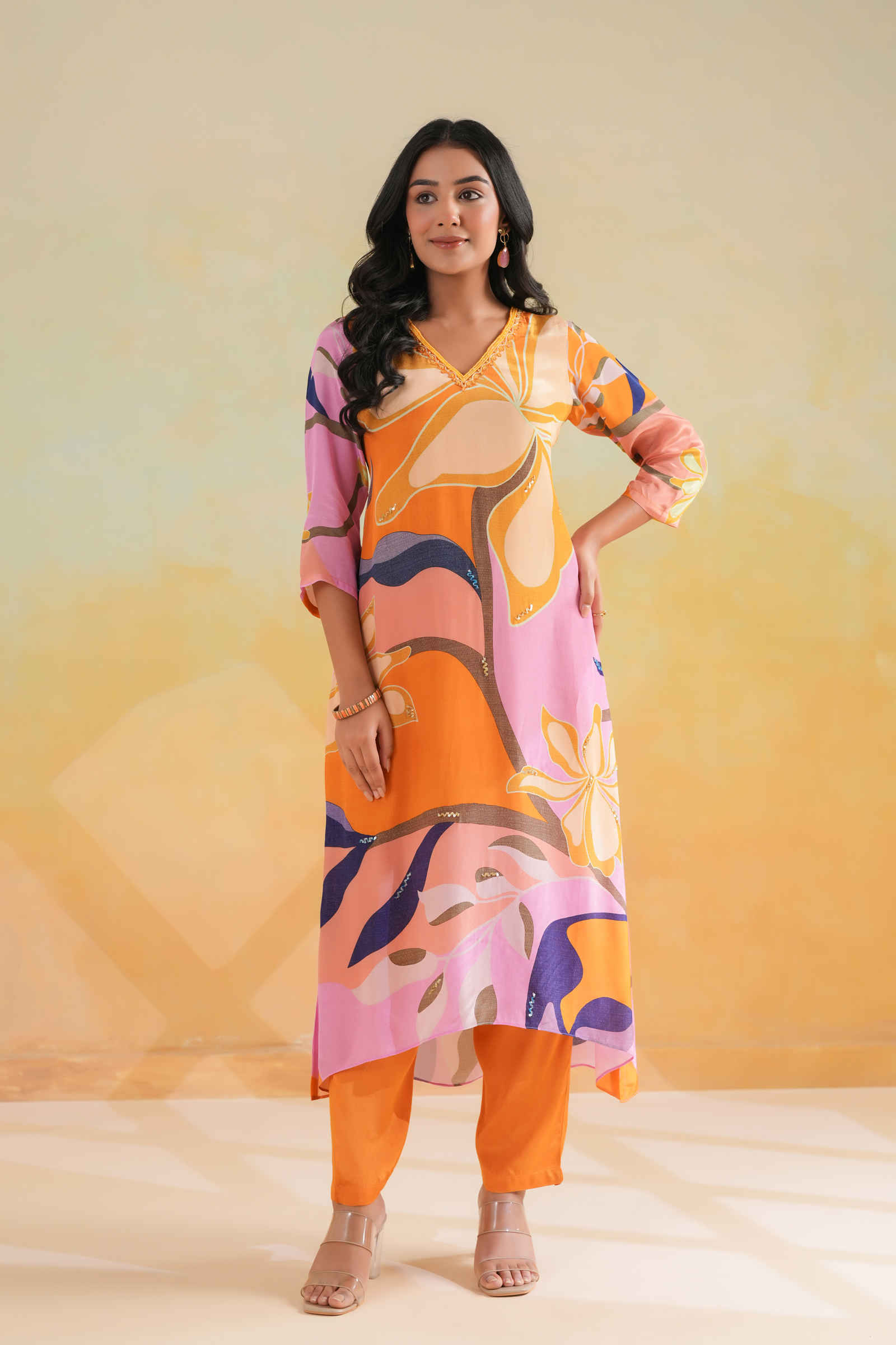 a bold and vibrant multicolor printed kurta with abstract floral patterns in shades of orange, pink, yellow, and navy — a cheerful, statement-making outfit perfect for summer days and casual celebrations.